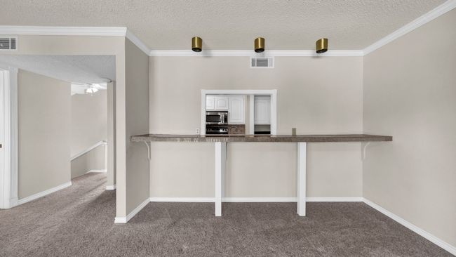 Kitchen featuring carpet, crown molding, kitchen bar seating | Image 9