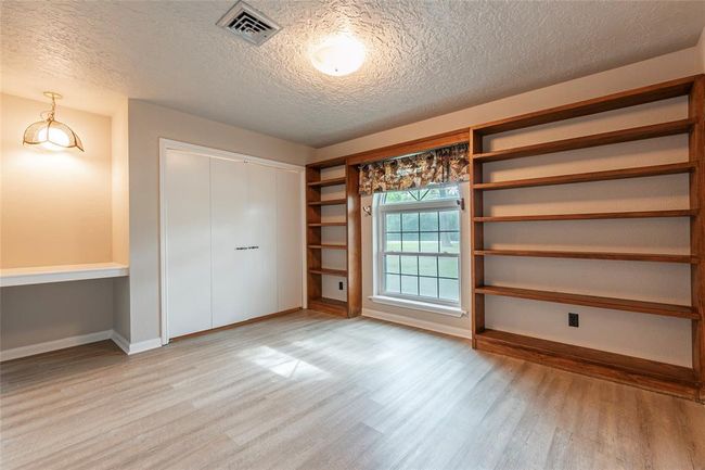guest room at the front of the home with built in shelves | Image 15