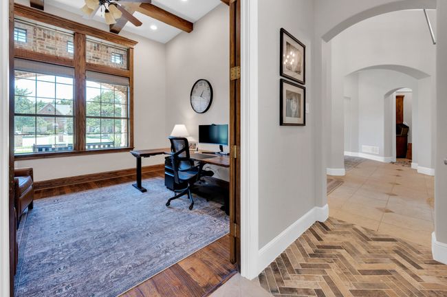 Office area featuring arched walkways, ceiling fan, beamed ceiling, and a high ceiling | Image 19