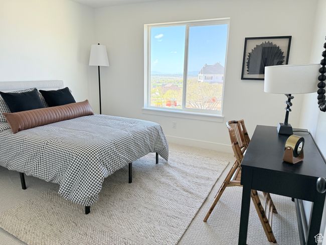 Carpeted bedroom with baseboards and an office area | Image 12