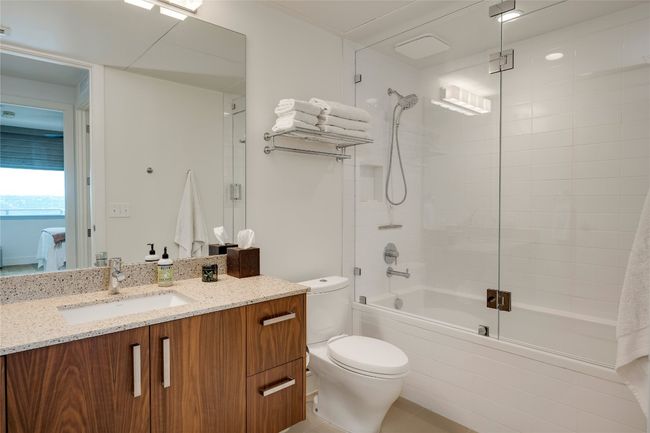 Bathroom featuring vanity and combined bath / shower with glass door | Image 11