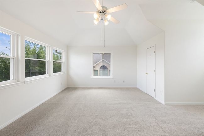 Spare room featuring light colored carpet, ceiling fan, and lofted ceiling | Image 29