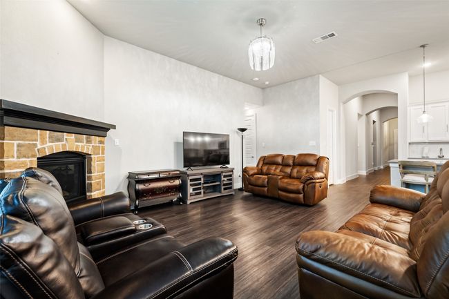 Living room featuring dark hardwood / wood-style flooring and a stone fireplace | Image 8