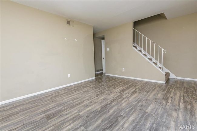 Unfurnished living room with wood finished floors and stairs | Image 4