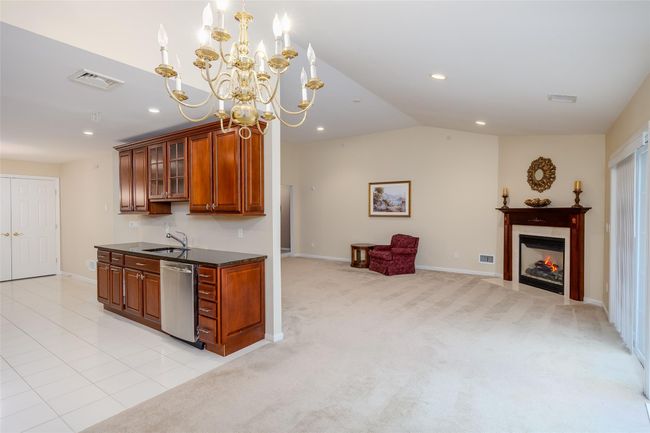 Kitchen with dishwasher, dark countertops, brown cabinets, open floor plan, and recessed lighting | Image 9
