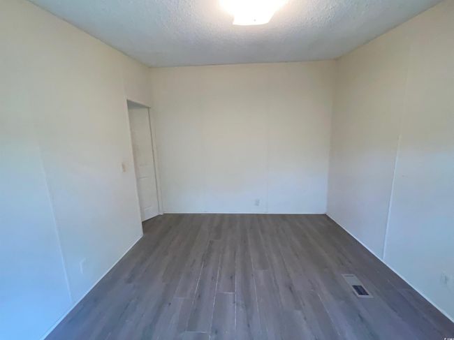 Unfurnished room with visible vents, wood finished floors, and a textured ceiling | Image 15
