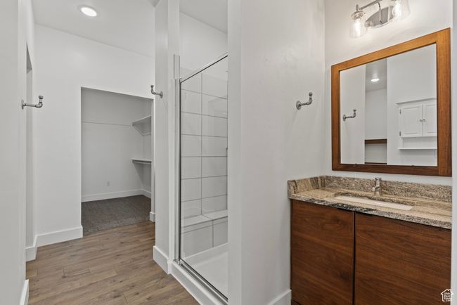 Bathroom featuring a stall shower, wood finished floors, vanity, baseboards, and recessed lighting | Image 17