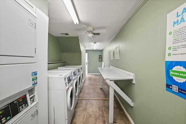Community laundry featuring stacked washer / dryer, independent washer and dryer, a textured ceiling, a ceiling fan, and wood finished floors | Image 36