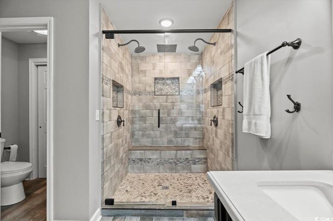 Bathroom featuring a stall shower, wood finished floors, toilet, and vanity | Image 22