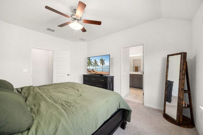 Bedroom with light carpet, a ceiling fan, and connected bathroom | Image 21
