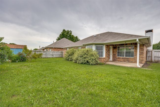 Rear view of property with a patio, a fenced backyard, brick siding, and a chimney | Image 13
