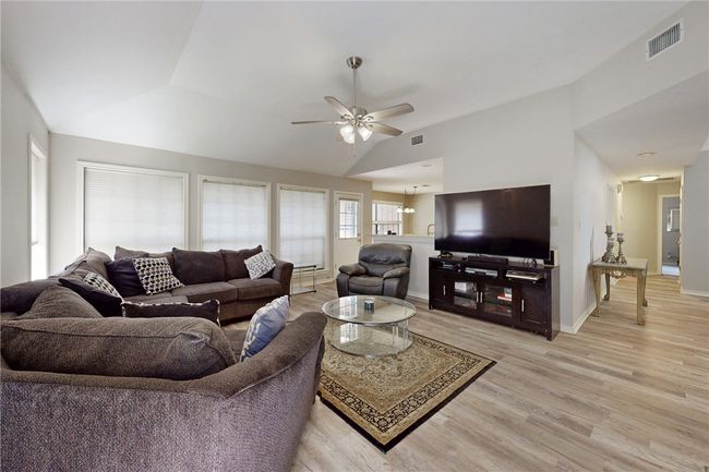 Living area featuring lofted ceiling, light wood-style floors, ceiling fan, and baseboards | Image 6