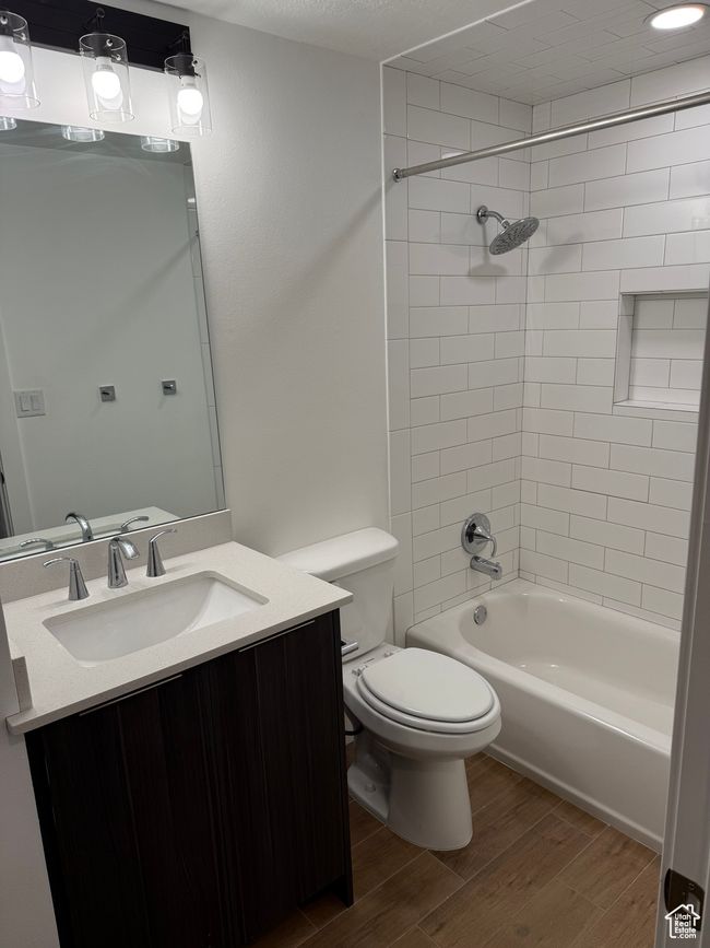 Bathroom with bathing tub / shower combination, vanity, toilet, and wood finished floors | Image 11