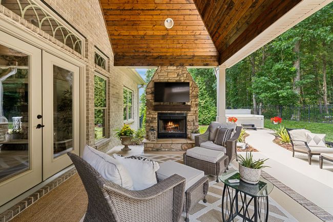Upgraded features - Stone wood burning Fireplace, Stone base pillars, and 3/4" stained and finished pine wood ceilings. | Image 49