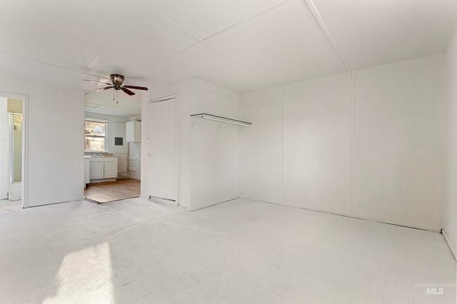 Unfurnished bedroom featuring concrete floors, ensuite bathroom, and ceiling fan | Image 24