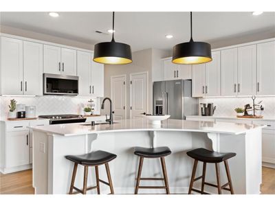 A truly one-of-a-kind kitchen island is the center piece of this kitchen. Equally beautiful and functional. This island is sure to impress while allowing for any undertaking in the kitchen! Photo of model home. | Image 2