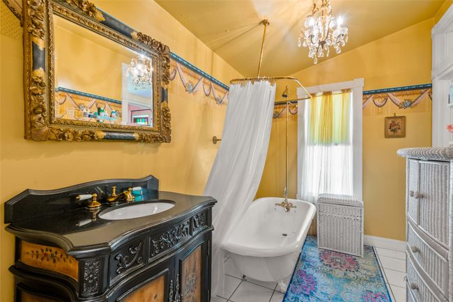 Bathroom with vanity, tile patterned flooring, a shower with shower curtain, and a freestanding tub | Image 18