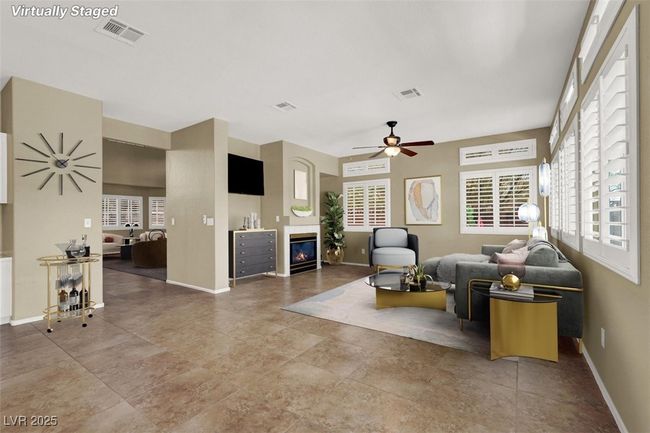 Living area with ceiling fan and a glass covered fireplace | Image 9