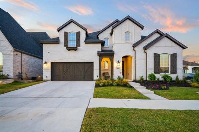 French provincial home featuring a yard and a garage | Image 1