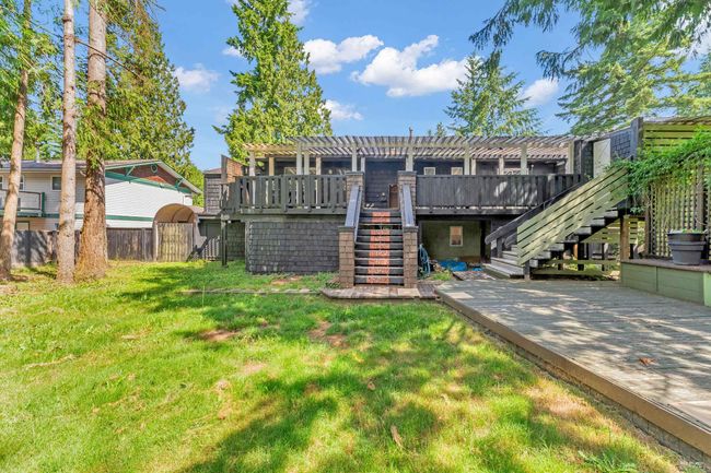 Back of property featuring a lawn, stairway, fence, and a pergola | Image 33