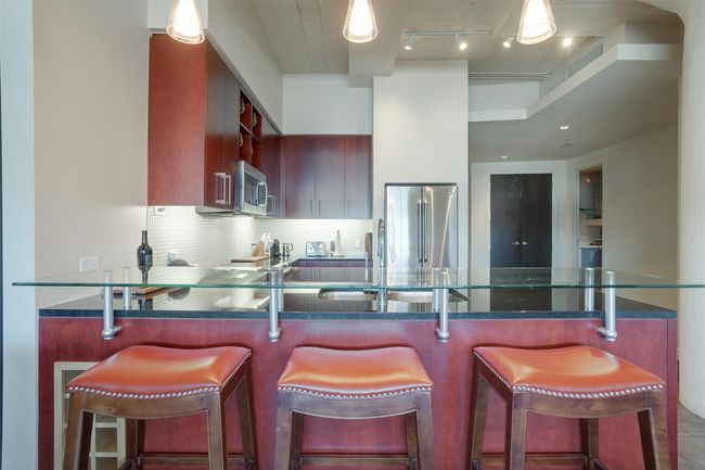 Kitchen with stainless steel appliances, tasteful backsplash, a peninsula, and dark stone counters | Image 16
