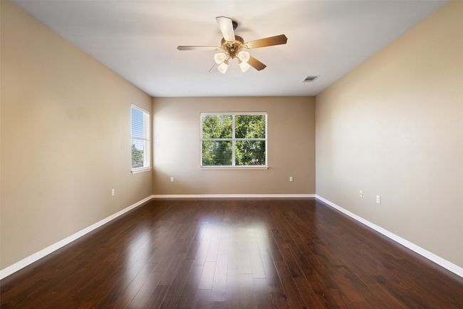 Spare room featuring ceiling fan, baseboards, and wood finished floors | Image 23