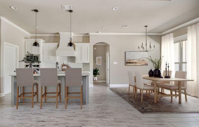 Kitchen with a breakfast bar area, crown molding, hanging light fixtures, white cabinetry, and custom exhaust hood | Image 3