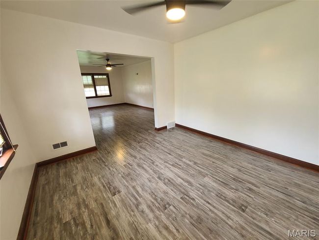 Empty room with ceiling fan and dark wood finished floors | Image 5