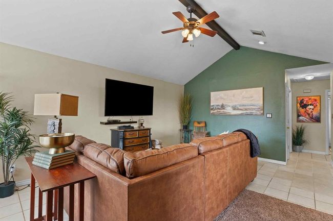 Beautifully styled living room with high, slanted ceilings and a bold central beam—thoughtful decor makes this space feel both modern and inviting. | Image 6