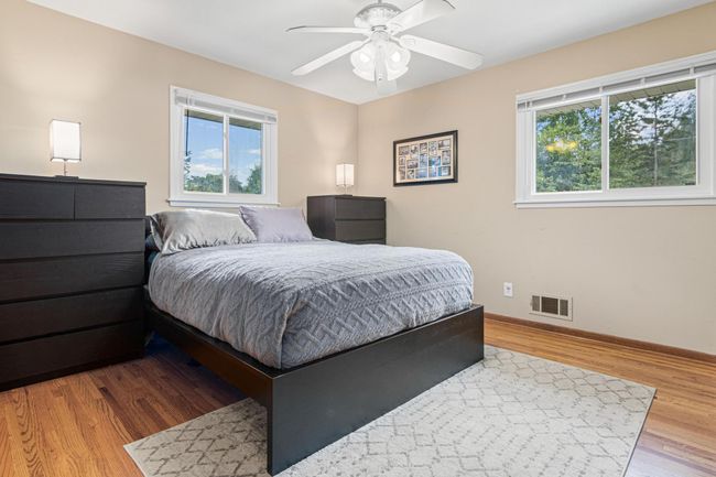 Main level primary bedroom with a walk-in closet and plenty of room for a queen or king-sized bed, dressers and sitting area. | Image 10