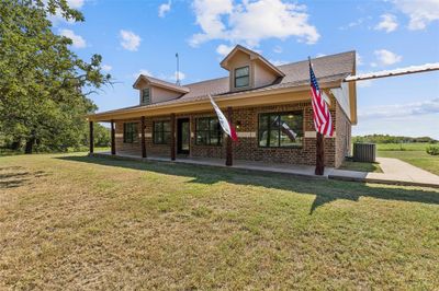 Rear view of house featuring a lawn, a porch, and central AC | Image 3