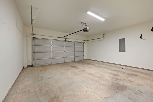 Garage featuring electric panel and a garage door opener | Image 35