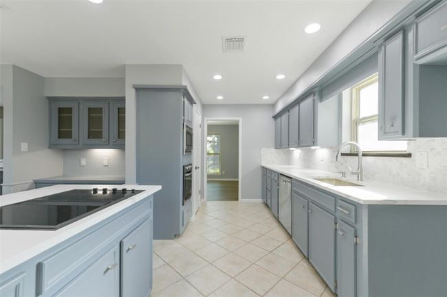 Kitchen with cooktop stove. Plenty of counter space. Built in desk with upper cabinets. | Image 6