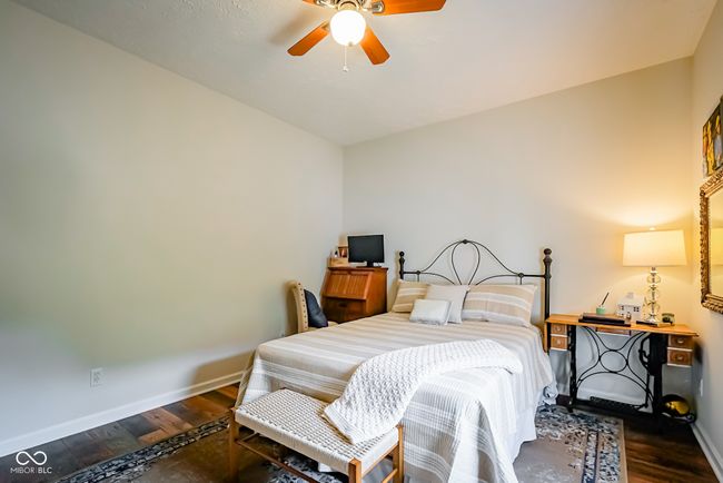 bedroom with baseboards, wood finished floors, and a ceiling fan | Image 21