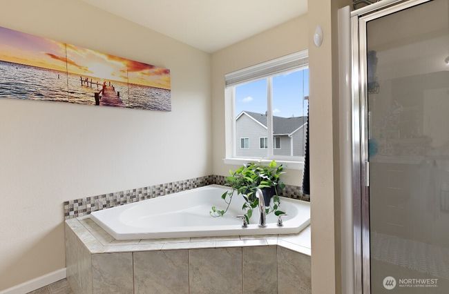 Spa-inspired ensuite bath features a deep soaking tub, separate shower, and dual vanities for ultimate comfort. | Image 22