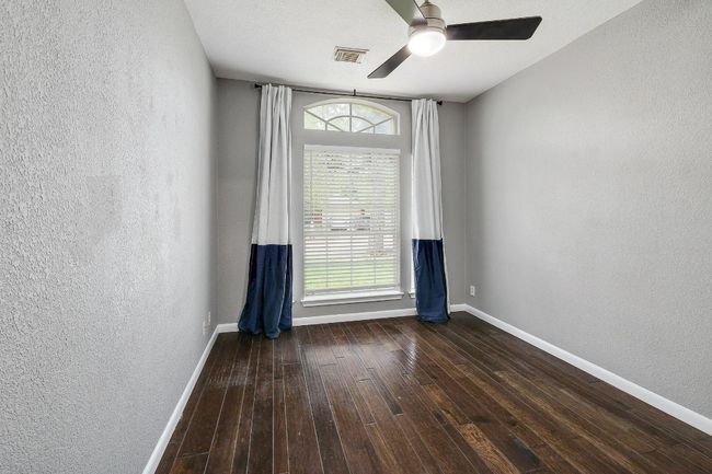 Empty room featuring baseboards, a textured wall, wood-type flooring, and visible vents | Image 27
