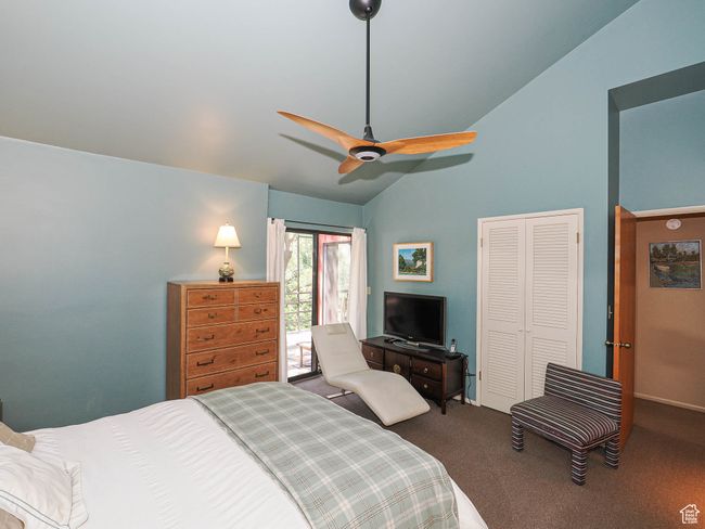 Carpeted bedroom featuring lofted ceiling, a closet, access to outside, and ceiling fan | Image 28