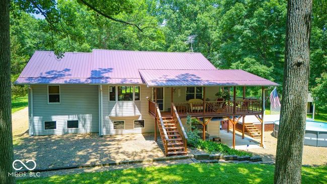 view of front facade featuring stairs, a patio area, a metal roof, and a deck | Image 5