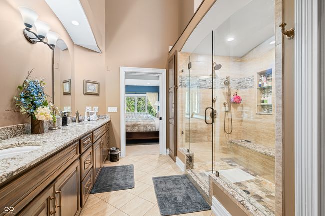 ensuite bathroom featuring double vanity, a shower stall, ensuite bath, and tile patterned flooring | Image 44