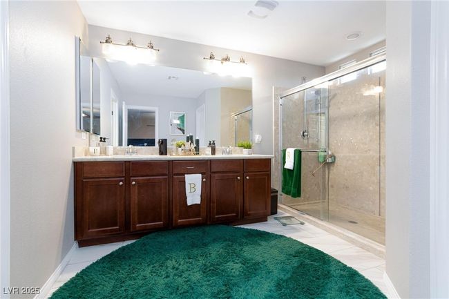 Full bath with a shower stall, tile patterned floors, a sink, double vanity, and carpet flooring | Image 24