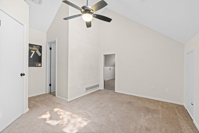 Unfurnished bedroom with carpet flooring, high vaulted ceiling, and ceiling fan | Image 20