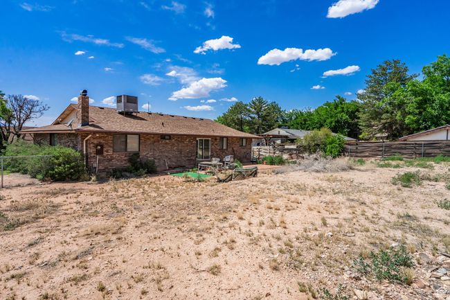 Rear view of house featuring a chimney, a fenced backyard, and brick siding | Image 55