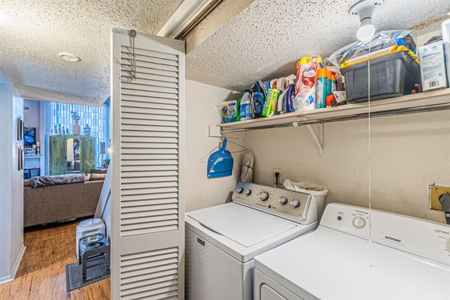 Laundry area featuring separate washer and dryer, a textured ceiling, and light wood finished floors | Image 13