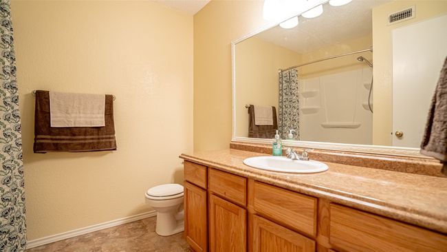 Full bathroom featuring toilet, vanity, baseboards, and a shower with curtain | Image 11