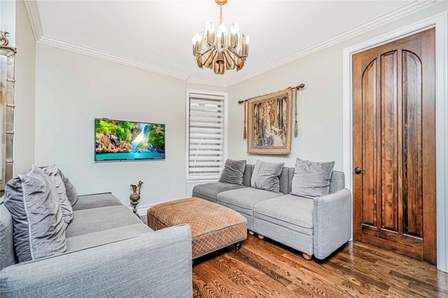 Living area featuring a chandelier, crown molding, and wood finished floors | Image 4