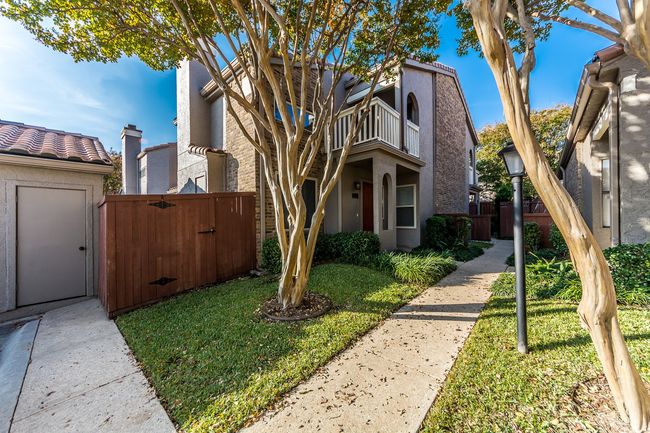 View of front facade featuring a front lawn, a gate, fence, a balcony, and stucco siding | Image 18