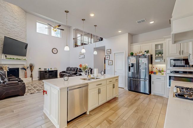 Kitchen featuring open floor plan, light countertops, visible vents, a ceiling fan, and appliances with stainless steel finishes | Image 9
