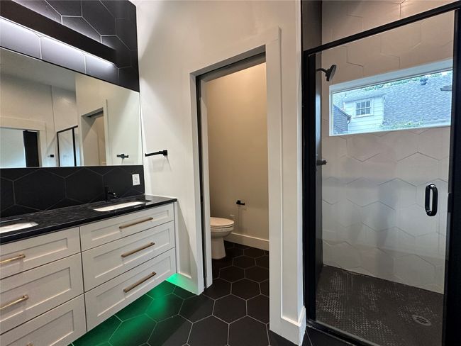 Bathroom with a shower stall, double vanity, tile patterned floors, and decorative backsplash | Image 28
