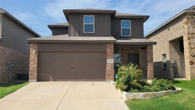 View of front of home with a garage, central AC unit, and a front yard | Image 1