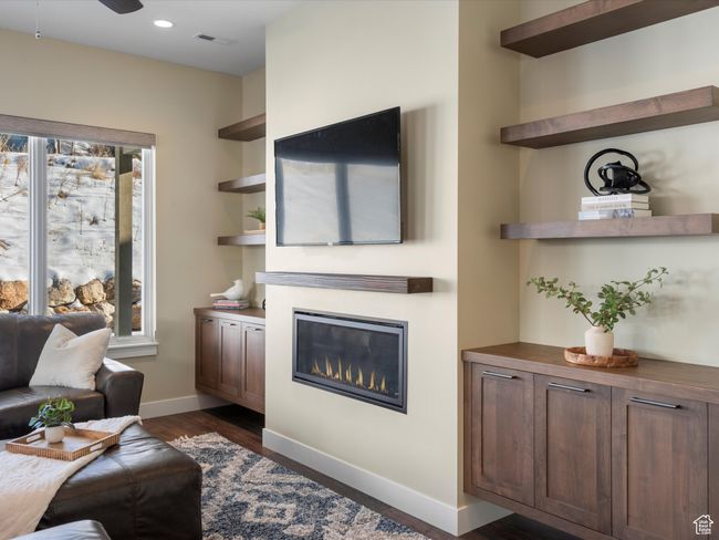 Living room featuring a glass covered fireplace, dark wood finished floors, baseboards, recessed lighting, and ceiling fan | Image 17